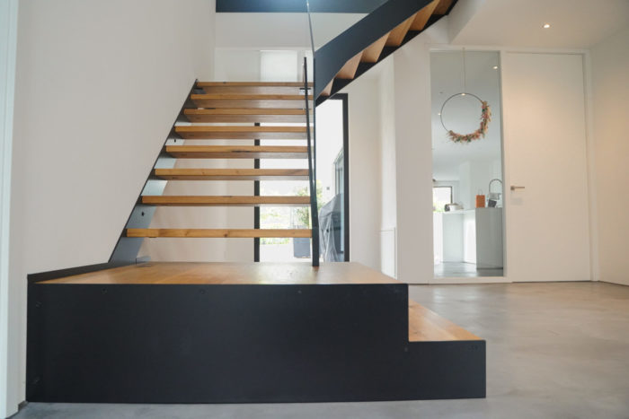 Podest Treppe mit schwarzen Stahlwangen und Glasgeländer, mit Antrittspodest