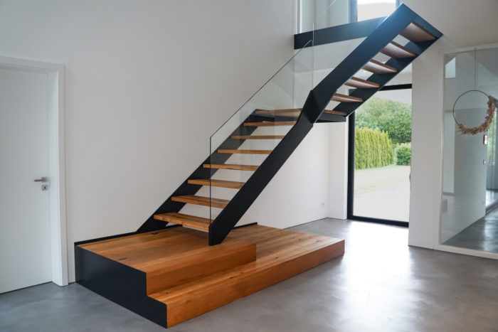 Podest Treppe mit schwarzen Stahlwangen und Glasgeländer, mit Antrittspodest